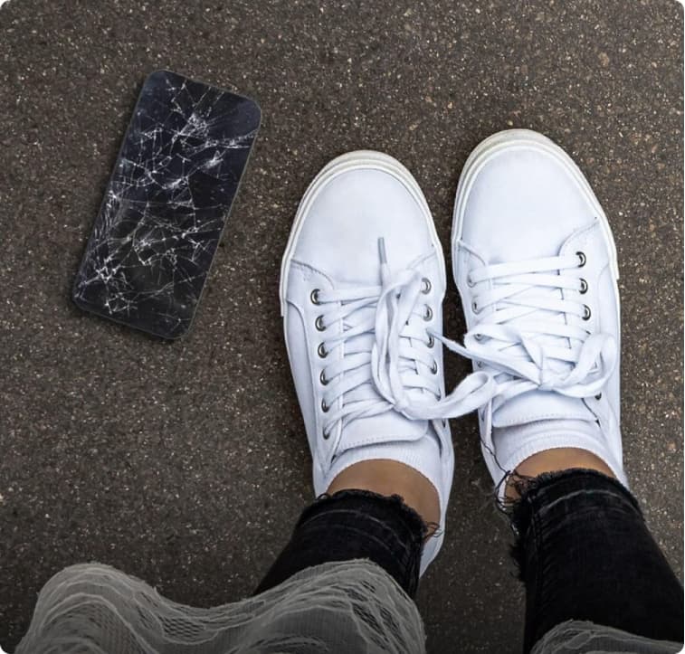 cracked screen at the base of women's feet